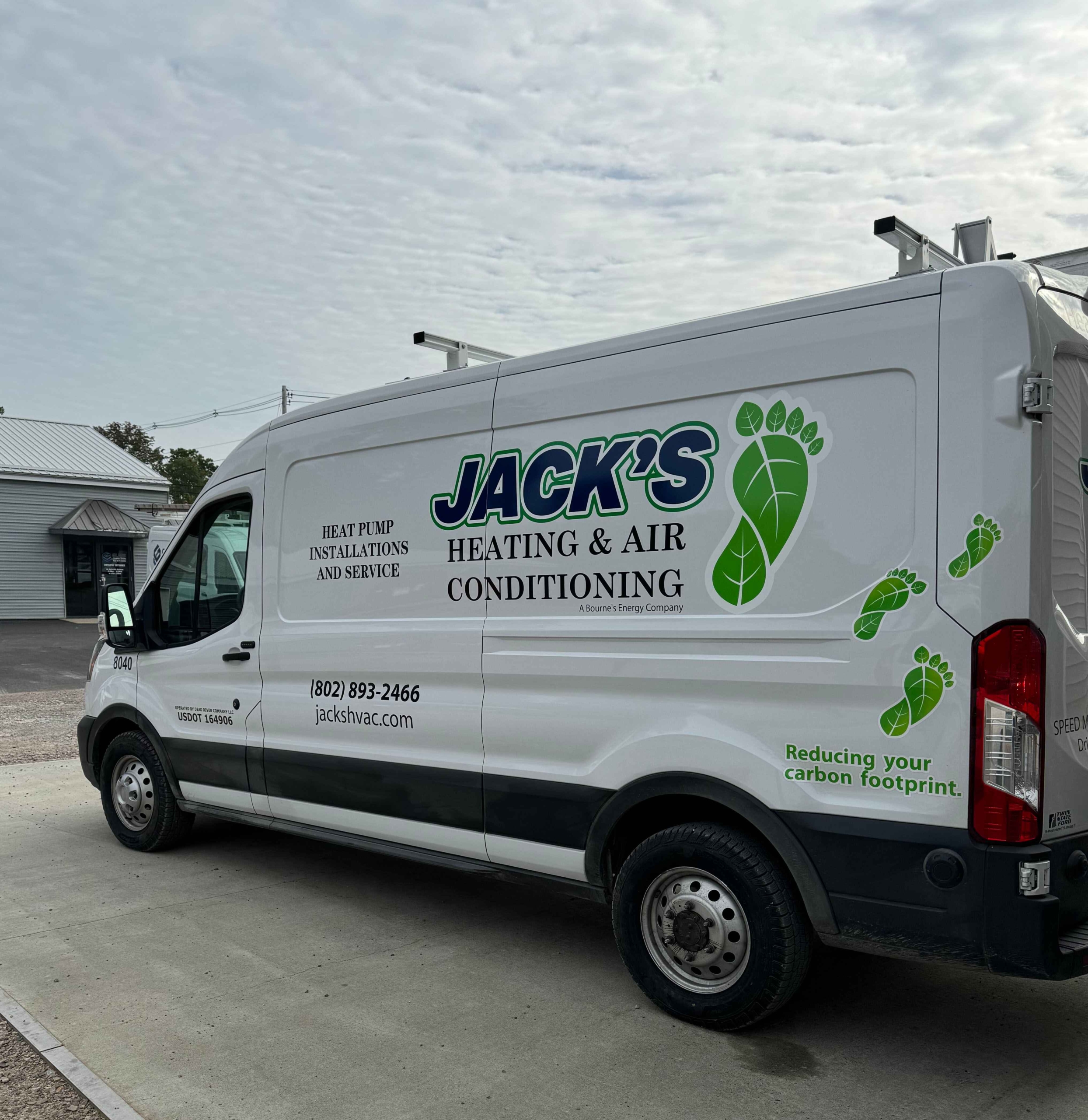 Photo of a Jacks JVAC truck with our new green and blue logo outside our office in Milton, VT